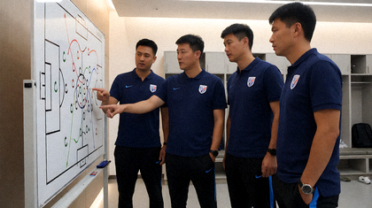 教练团队在场边查看战术板并进行比赛分析