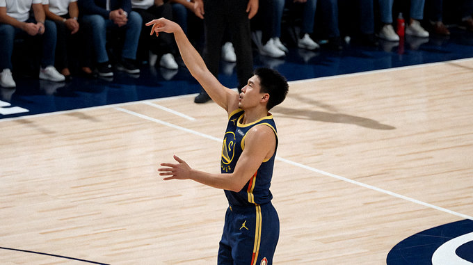 NBA 篮球比赛现场，球员在三分线外出手投篮
