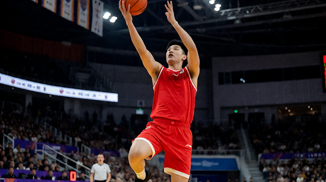 NBA篮球比赛现场，球员在篮下完成上篮动作
